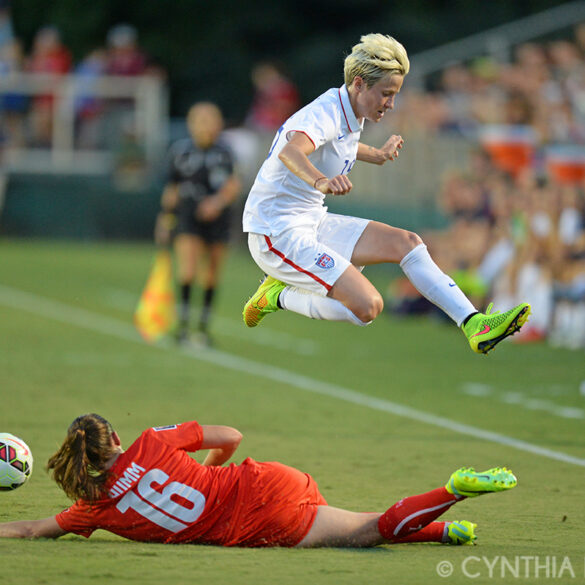 Megan Rapinoe avoids a sliding Fabienne Humm during the friendly between the United States and Switzerland on August 20, 2014, in Cary, N.C.