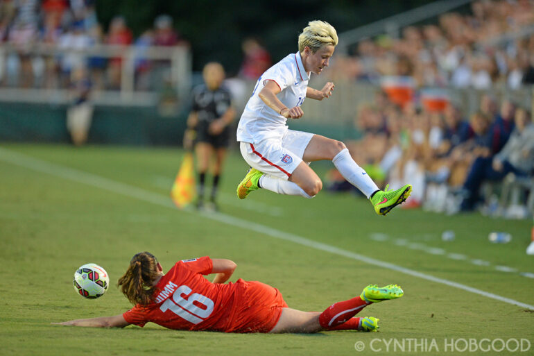 Megan Rapinoe avoids a sliding Fabienne Humm during the friendly between the United States and Switzerland on August 20, 2014, in Cary, N.C.