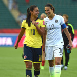 Colombia's Yoreli Rincón and the USA's Carli Lloyd catch up after a Round of 16 match during the 2015 FIFA Women's World Cup.