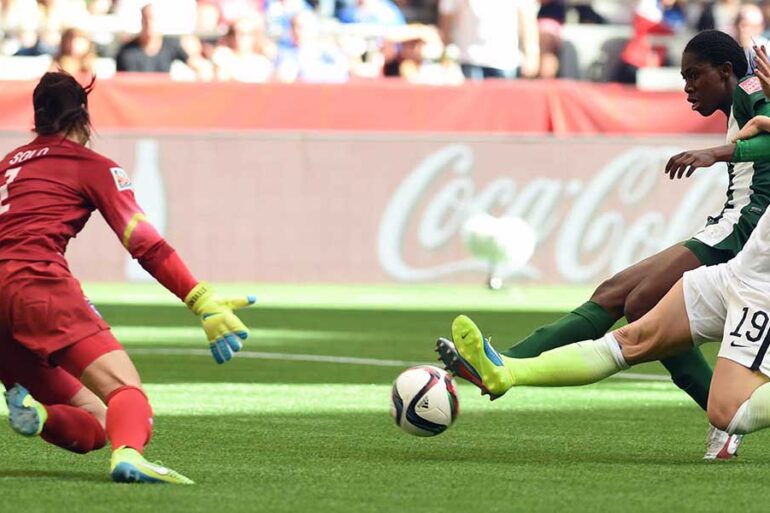 Julie Johnston tackles the ball away from Asisat Oshoala.