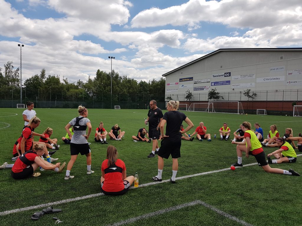 Wadsworth and Ward speak to the squad after a tough session in the heat. (Photo: Rich Laverty)