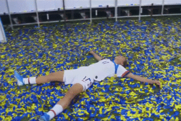 Tobin Heath lying in confetti after winning the 2019 World Cup in .gif format.