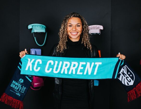 Michelle Cooper, the Kansas City Current's draft pick, holds up a Current scarf at the 2023 NWSL College Draft. (Kansas City Current Twitter)